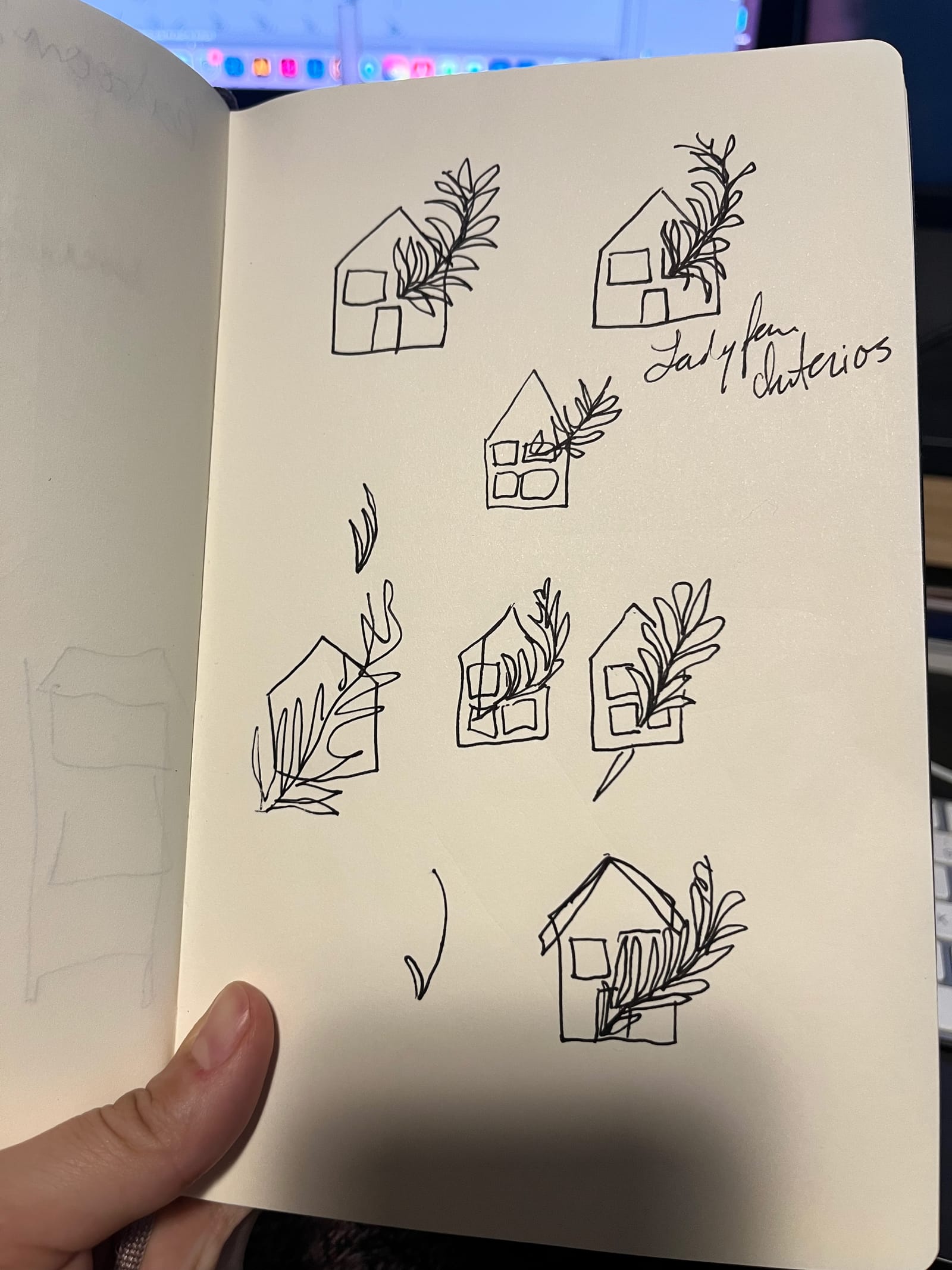 A sketchbook page of hand-drawn Ladyfern logo concepts — small houses framed by ferns